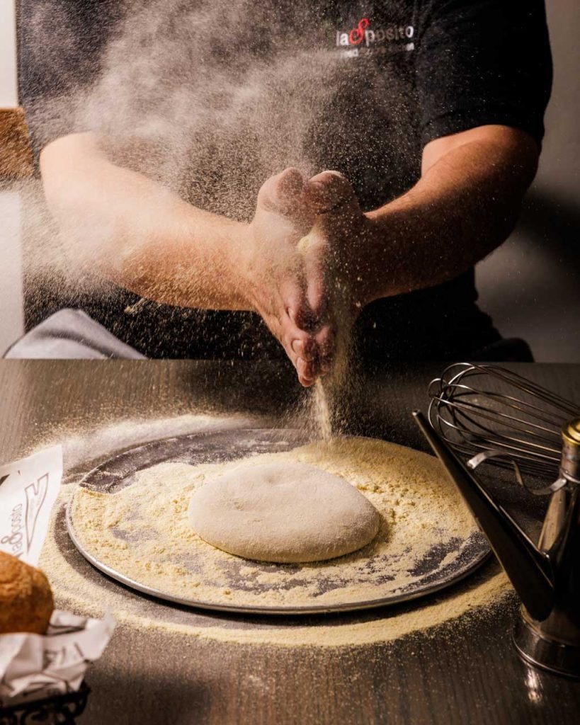 A chef hand-shaping fresh dough in the kitchen