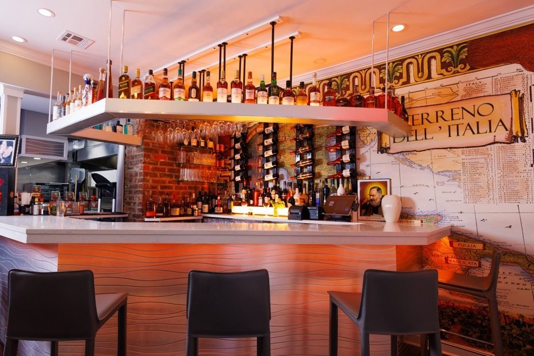 The full bar at Via Sposito Colts Neck with a map of Italy mural